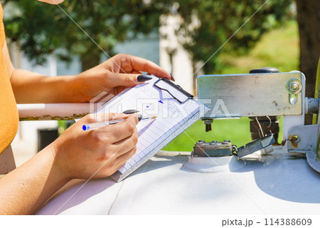 Woman checking level of propane gas in tank 114388609