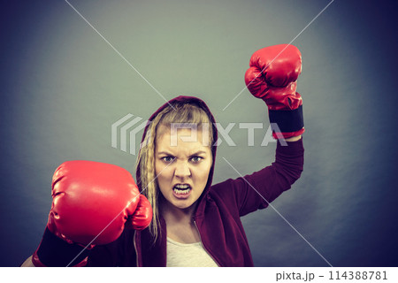 Angry woman wearing boxing gloves Angry woman wearing boxing gloves 114388781