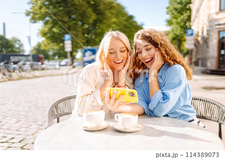 Two young women sitting in the cafe. Coffee break after shopping. Blogging, tourism. Two young women sitting in the cafe. Coffee break after shopping. Blogging, tourism. 114389073