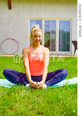 Woman exercising in garden at home 114389152