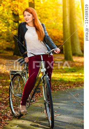 Beauty girl relaxing in autumn park with bicycle, outdoor 114389329