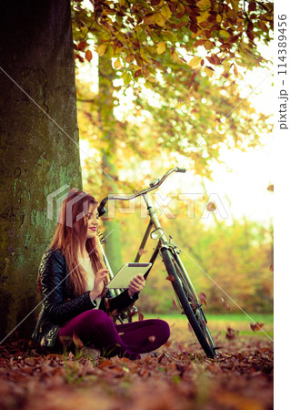 Girl under tree with bike. Girl under tree with bike. 114389456