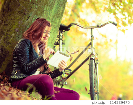 Redhead lady under tree. Redhead lady under tree. 114389470