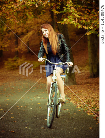 Girl in dress on bike. 114389476