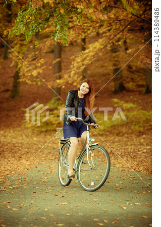Girl in dress on bike. 114389486