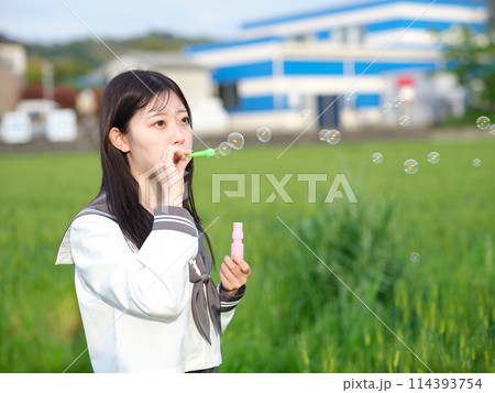 シャボン玉を吹く女子高生 114393754