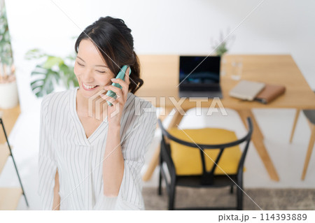 スマホで通話する女性 114393889