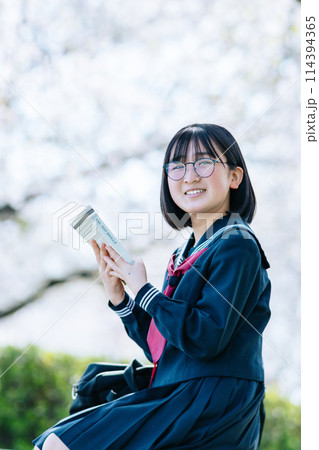 放課後屋外で読書をする高校生 114394365