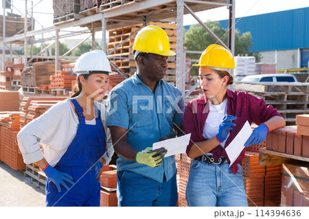 Builders discussing they're work in outdoor storage 114394636