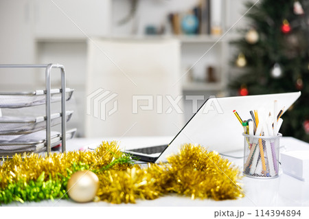 Laptop and christmas tinsel on table in office. Office workplace 114394894