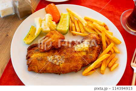 Fried breaded fish filet with french fries and pickled vegetables Fried breaded fish filet with french fries and pickled vegetables 114394913