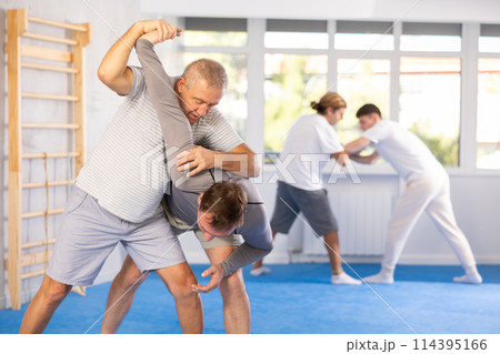 Adult and elderly men training judo fight 114395166