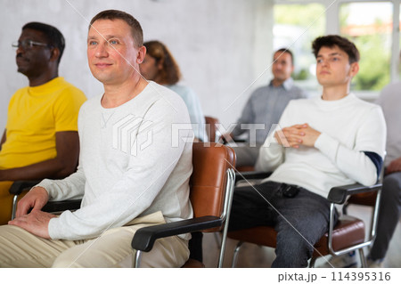 Man student listening to lecture with male coursemates Man student listening to lecture with male coursemates 114395316