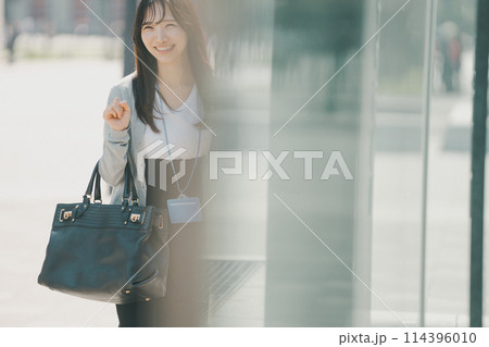 オフィス街を歩くラフな服装の若い働く女性 オフィス街を歩くラフな服装の若い働く女性 114396010