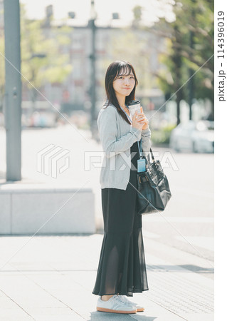 オフィス街に立つラフな服装の若い働く女性 オフィス街に立つラフな服装の若い働く女性 114396019