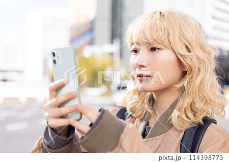 ストリートスナップ スマホを見ている若い女性 ストリートスナップ スマホを見ている若い女性 114398773