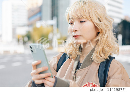 ストリートスナップ スマホを見ている若い女性 ストリートスナップ スマホを見ている若い女性 114398774