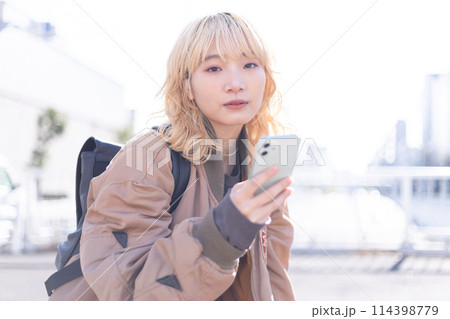 ストリートスナップ スマホを見ている若い女性 ストリートスナップ スマホを見ている若い女性 114398779