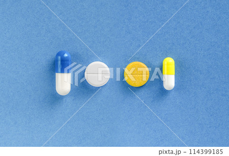 Some pills on blue colored background. Dietary supplements and vitamins Some pills on blue colored background. Dietary supplements and vitamins 114399185