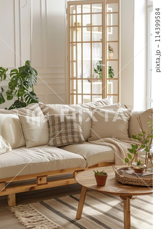 Modern living room with beige sofa, wooden coffee table, and multiple indoor plants. Modern living room with beige sofa, wooden coffee table, and multiple indoor plants. 114399584