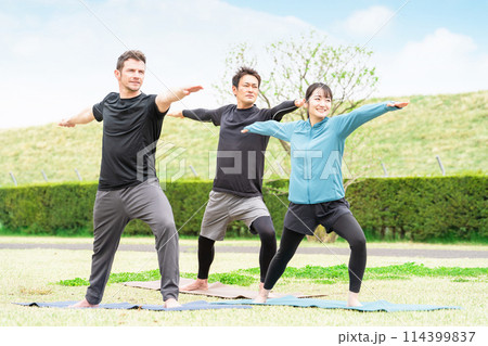 公園でピラティス・ヨガ教室をする男女(英雄のポーズ) 公園でピラティス・ヨガ教室をする男女(英雄のポーズ) 114399837