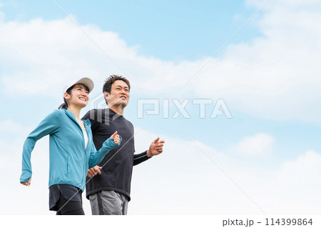 健康のため公園でウォーキング・散歩・有酸素運動するスポーツウェアを着た男女 114399864