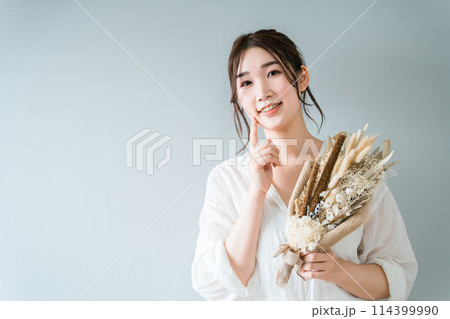ドライフラワーのスワッグを持つおしゃれな女性 ドライフラワーのスワッグを持つおしゃれな女性 114399990