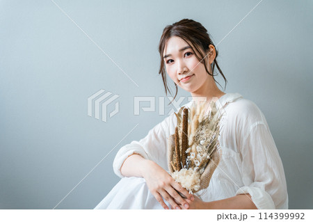 ドライフラワーのスワッグを持つおしゃれな女性 114399992