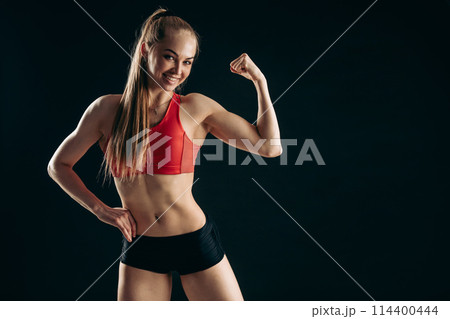 cheerful fit girl is showing her biceps cheerful fit girl is showing her biceps 114400444