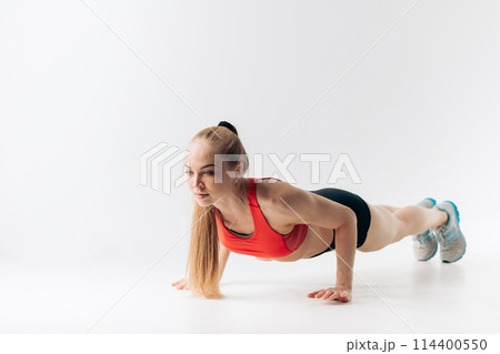 good looking pleasant girl is spending time at gym 114400550