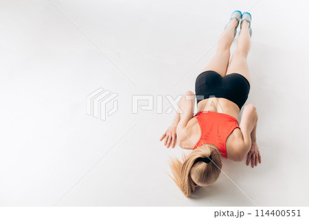sporty girl doing press ups on the floor 114400551