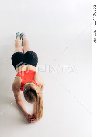 fit actiav egirl in sportswear is leaning on her elbows and doing exercises 114400552