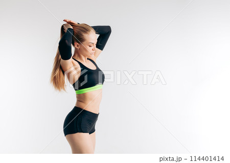 Pretty sportswoman is holding her ponytail. Pretty sportswoman is holding her ponytail. 114401414