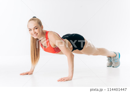 happy awesome fit girl is loking at the camera while pressing up happy awesome fit girl is loking at the camera while pressing up 114401447