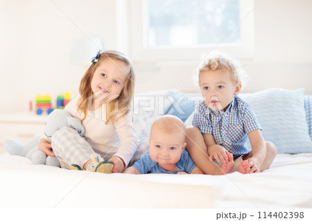 Kids in bed. Children in pajamas. Family bedroom. 114402398