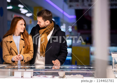 young caucasian married couple enjoy choosing jewelry for female 114402781