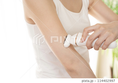 脱毛器を腕にあてる女性（顔無し） 114402997