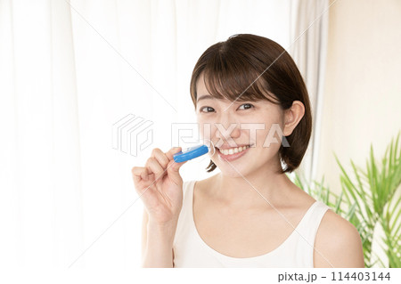 歯のホワイトニングをする女性 114403144