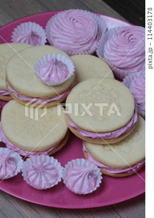 Cooked marshmallow sandwiches. They lie on plate. Next on the plate is a marshmallow of various sizes. Cooked marshmallow sandwiches. They lie on plate. Next on the plate is a marshmallow of various sizes. 114403178