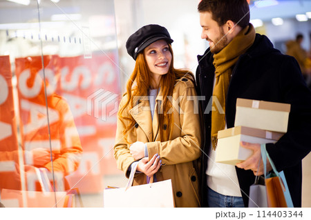 Beautiful couple on shopping trip in the shop center Beautiful couple on shopping trip in the shop center 114403344