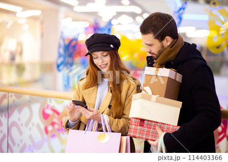 Young caucasian couple with smartphone in shopping mall 114403366