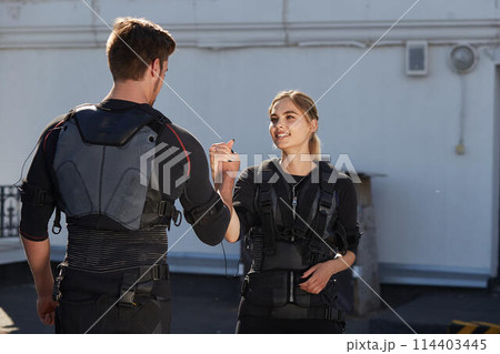 team workout concept. blond girl is thanking her personal coach for workout team workout concept. blond girl is thanking her personal coach for workout 114403445