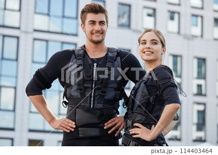 two pleasant people are happy because they have tested new EMS suits for the first time two pleasant people are happy because they have tested new EMS suits for the first time 114403464