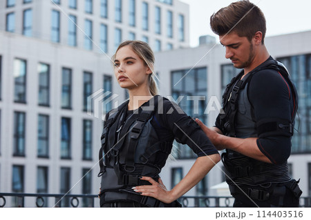 handsome trainer is preparing a beautiful worman for workout handsome trainer is preparing a beautiful worman for workout 114403516
