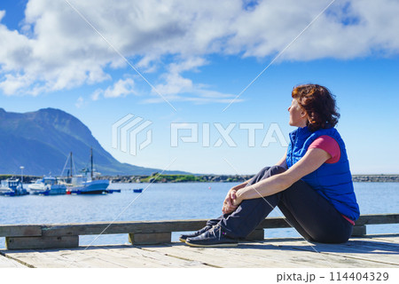 Tourist woman in fishing port, Lofoten Norway 114404329