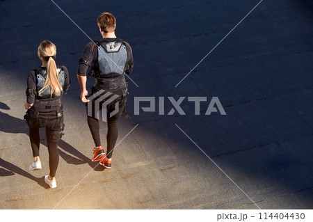 back view photo of active two people working out in EMS suits back view photo of active two people working out in EMS suits 114404430