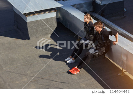 two athletes are performing knee bends two athletes are performing knee bends 114404442