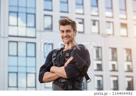 positive cheerful well-built man standing with crossed amrs and looking at the camera positive cheerful well-built man standing with crossed amrs and looking at the camera 114404492