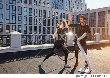 two young people giving high five to each other aafter reaching good results in fitness 114404515