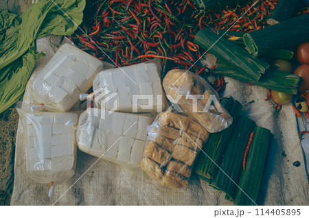 Overhead view of soy curd, fresh tofu or tahu and tempeh or fermented soybeans wrapped in banana leaf sold in the local market of Berastagi in North Sumatra, Indonesia 114405895